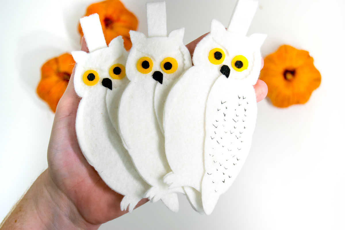 hand holding 3 Hedwig ornaments